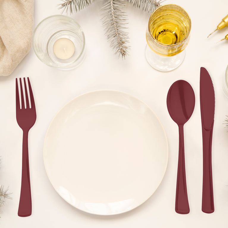 Red cutlery mixes with other red partyware for a colorful setup